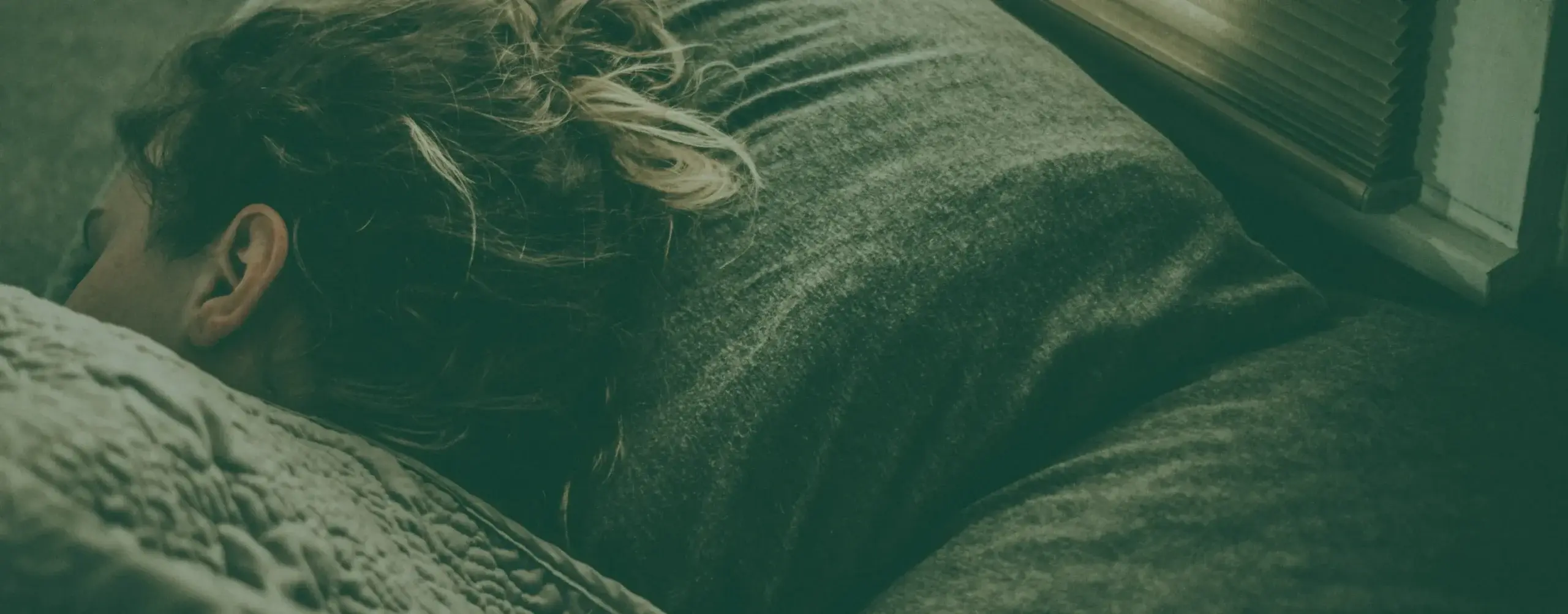 A person asleep in bed at night, resting quietly.