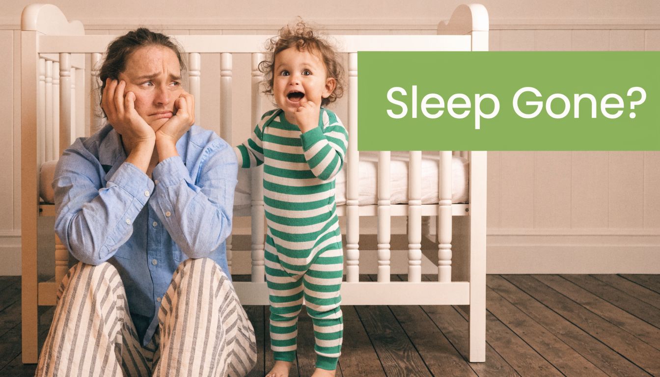 A tired mother sitting on the floor by a baby crib with her awake, energetic toddler.