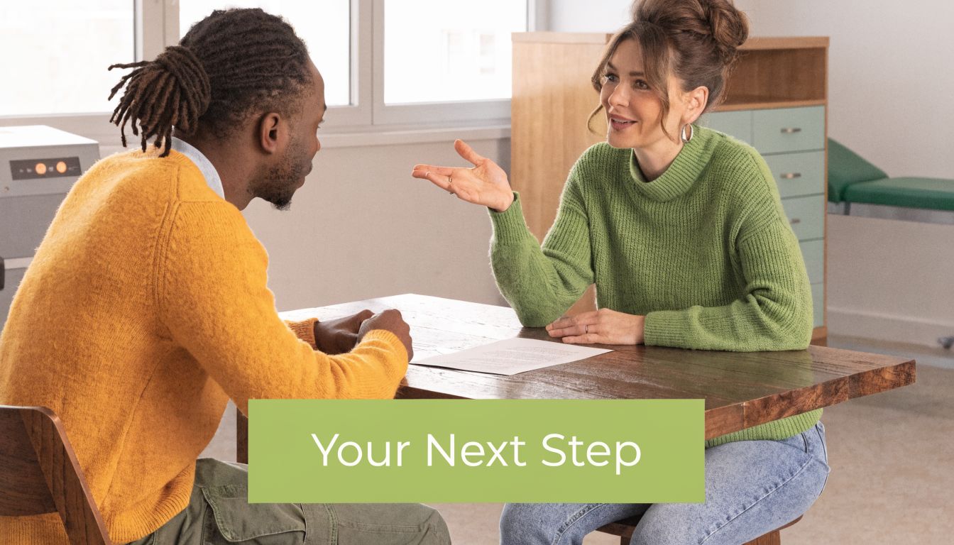 A professional woman in a green sweater talking to a man in a yellow sweater during a consultation.
