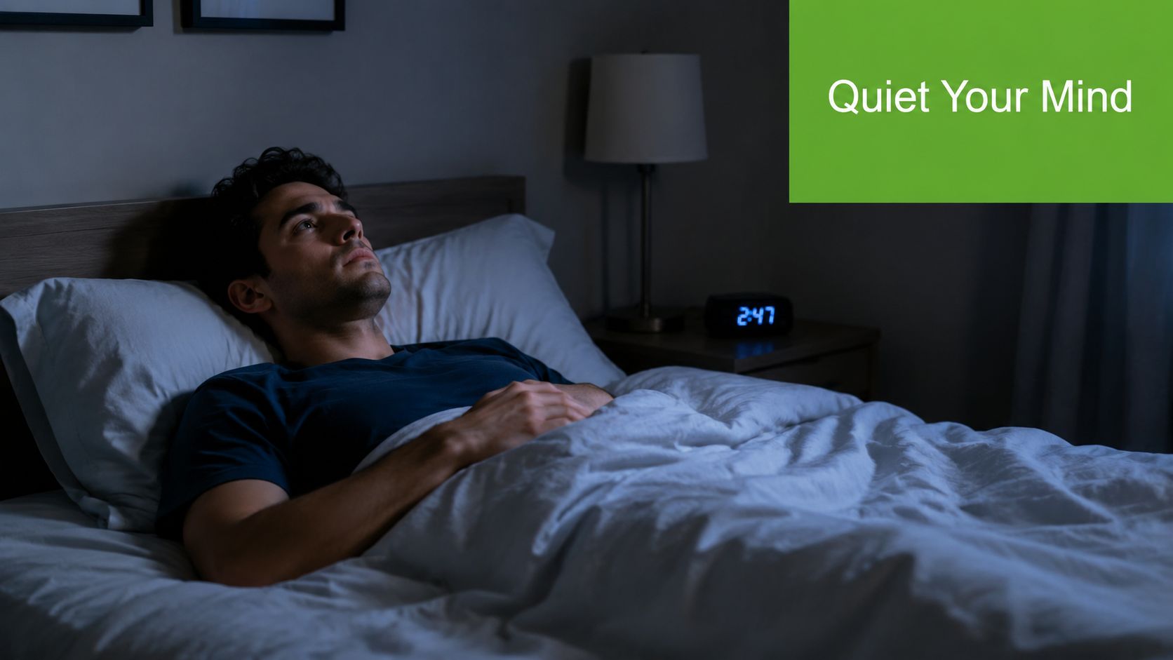 A man lying in bed at night, staring at the ceiling, experiencing difficulty falling asleep.
