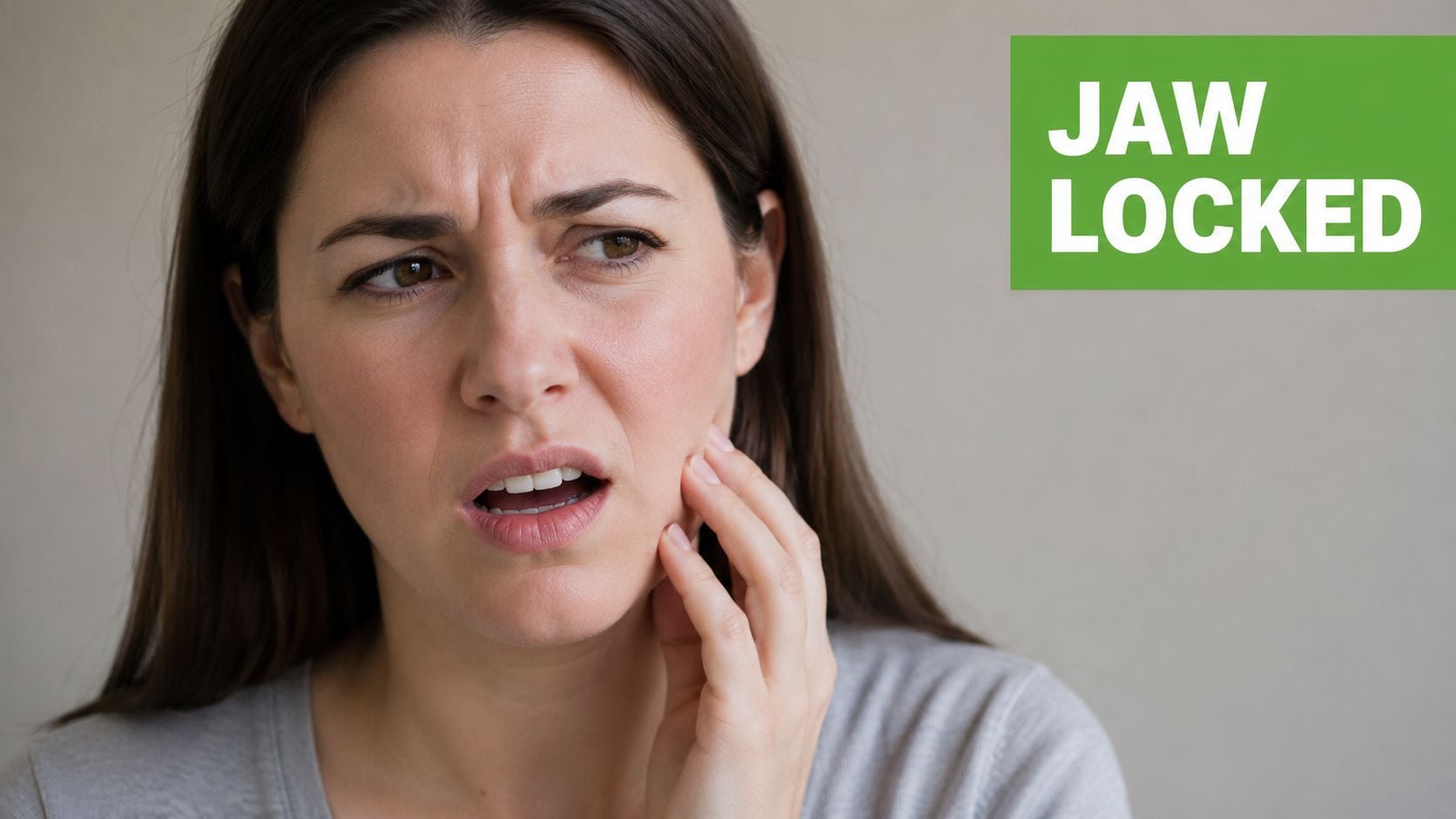 A woman experiencing discomfort while holding her jaw, suggesting she may have a locked jaw condition.