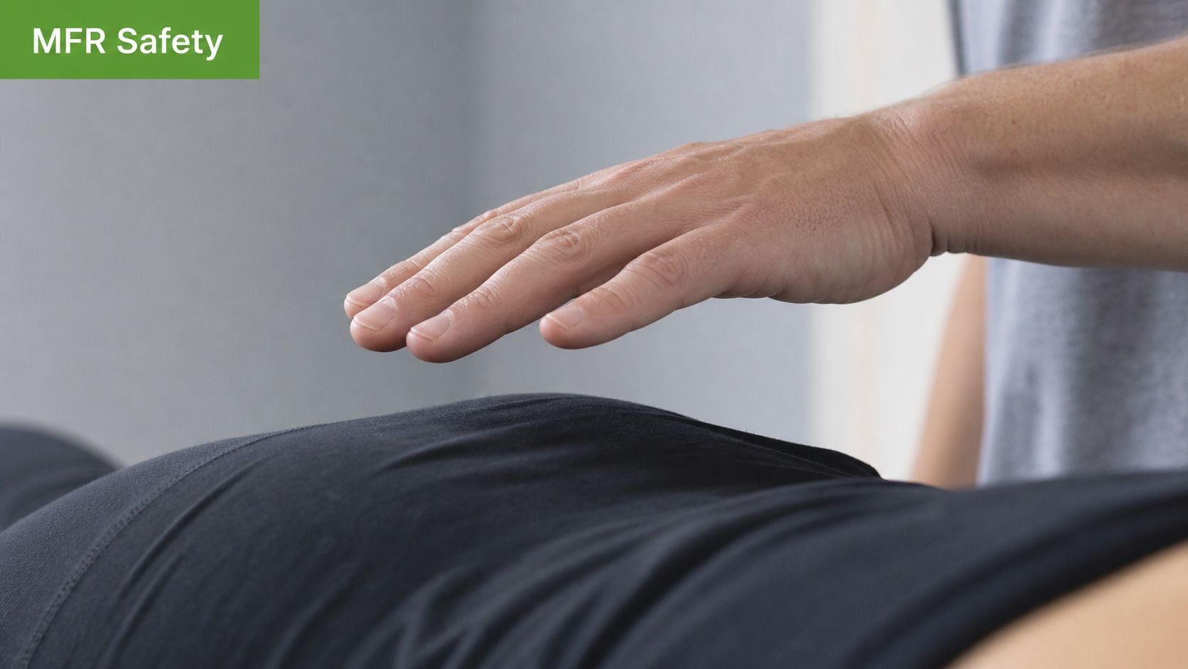 A practitioner performing a gentle myofascial release technique by hovering a hand over a patient's abdomen.